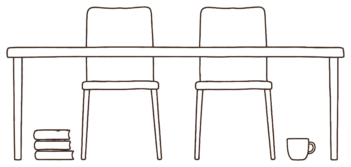 Two chairs side by side at a table, a small stack of books in front of one and a mug in front of the other